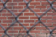 Crossbar fence and brick wall.